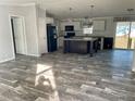 Open concept kitchen with island, stainless steel appliances, and wood-look flooring at 11625 Nw 20Th St, Ocala, FL 34482