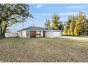 Charming single-story home featuring modern color accents, attached garage, and a spacious front yard at 13573 Sw 115 Pl, Dunnellon, FL 34432