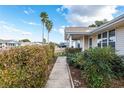 Landscaped front walkway leads to this charming home, enhanced by lush greenery and tall palm trees at 8968 Sw 116Th Place Rd, Ocala, FL 34481