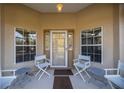 Inviting front porch with white chairs and a brown welcome mat at 21 Fisher Trail Pass, Ocklawaha, FL 32179