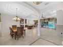 Spacious dining room with coffered ceilings, tile floors, and a view of the kitchen and pool area at 3907 Se 10Th Ave, Ocala, FL 34480