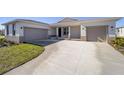 Two-car garage, light colored house with neutral colored trim at 7781 Sw 59Th Ln, Ocala, FL 34474