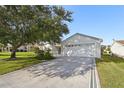 Attached garage with decorative driveway at 2427 Due West Dr, The Villages, FL 32162