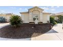 Landscaped front yard of a single story house with a curved driveway at 2840 Leicester Ter, The Villages, FL 32162