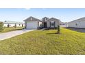 Newly built home with a large driveway and grassy lawn at 7772 Sw 56Th Pl, Ocala, FL 34474