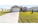 Newly built home with a large driveway and grassy lawn at 7772 Sw 56Th Pl, Ocala, FL 34474