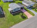 Single-wide manufactured home with a carport and a palm tree at 816 Hibiscus Dr, The Villages, FL 32159