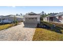 Single story home with gray garage door and paver driveway at 10218 Sw 99Th Ln, Ocala, FL 34481