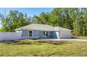 Newly built home with a light blue exterior, white fence, and a spacious backyard at 28 Dogwood Drive Pass, Ocala, FL 34472