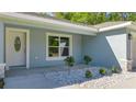 Front entrance with white door, light blue exterior, and landscaping at 28 Pecan Run, Ocala, FL 34472