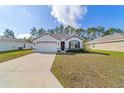 One-story home with a two-car garage and landscaping at 451 Hickory Course Loop, Ocala, FL 34472