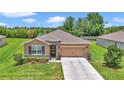 Charming home features manicured lawn, stone accents, two-car garage, and inviting front entrance at 6365 Sw 88Th Loop, Ocala, FL 34476