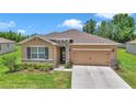 Inviting home with stone details, well-kept lawn, two-car garage, and neutral color scheme at 6365 Sw 88Th Loop, Ocala, FL 34476