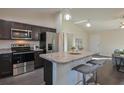 Modern kitchen with dark cabinetry, stainless steel appliances, and an island with seating at 13351 Sw 83Rd Cir, Ocala, FL 34473