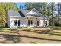 White farmhouse exterior with a front porch and landscaping at 15851 Nw 115Th Ct, Reddick, FL 32686