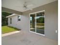 Covered back patio with a ceiling fan and a view of the backyard through sliding glass doors at 174 Pine Crse, Ocala, FL 34472