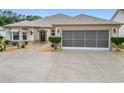 House exterior showcasing a screened garage and well-kept yard at 2117 Sansores St, The Villages, FL 32159