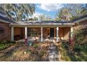 Charming home with brick exterior and covered front porch with white columns and rocking chairs at 10249 Nw 21St St, Ocala, FL 34482