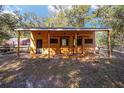 Exterior view of the horse stall featuring three bays with sliding doors and attached shed roof at 10249 Nw 21St St, Ocala, FL 34482