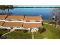 Lakefront property with two-story condo, lush landscaping, and walkway at 11001 Se Sunset Harbor Rd # B10, Summerfield, FL 34491