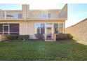 Backyard view of condo featuring sliding glass doors, upper balcony, and green grass at 11001 Se Sunset Harbor Rd # F45, Summerfield, FL 34491