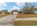 Front view of a house with a driveway and mature trees at 3720 Se 24Th St, Ocala, FL 34471