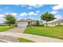 Charming single-story home featuring a well-manicured lawn, brick driveway, and tasteful landscaping under a blue sky at 6407 Sw 45Th Ave, Ocala, FL 34474