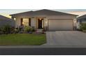 Exterior shot of a charming single-story house with a well-maintained lawn and a two-car garage at dusk at 7682 Sw 89Th Ct, Ocala, FL 34481