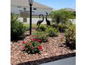 Landscaped front yard with floral accents and decorative yard art in a well maintained lawn at 7682 Sw 89Th Ct, Ocala, FL 34481