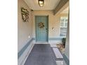 Close-up of the front door with a decorative wreath and a welcoming entrance to the home at 113 Guava Ter, Ocklawaha, FL 32179