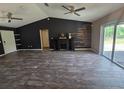 Spacious living room featuring wood-like tile floors, a decorative fireplace, and large windows at 113 Guava Ter, Ocklawaha, FL 32179