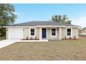 Inviting single-story home with a neatly manicured lawn, attached garage, and a charming front door at 14977 Sw 21St Pl, Ocala, FL 34481