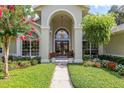 Elegant home entrance with lush landscaping and double doors at 2215 Se Spring Hill Ct, Ocala, FL 34471