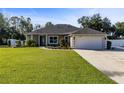 One story house with a two car garage and a large green lawn at 36323 Piney Ridge Blvd, Fruitland Park, FL 34731