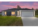 Charming one-story home showcasing a modern gray and white exterior with well-manicured lawn and an ample driveway at 4393 Sw 169 Lane Rd, Ocala, FL 34473