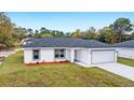 Newly built home features a gray garage door and well-manicured lawn at 4393 Sw 169 Lane Rd, Ocala, FL 34473