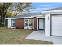 Inviting front yard view with a well-maintained lawn and modern architectural details on the home's facade at 4393 Sw 169 Lane Rd, Ocala, FL 34473