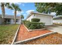 Front yard with walkway to garage and well-manicured landscaping at 9260 Sw 92Nd Place Rd, Ocala, FL 34481