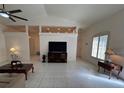 Bright living room featuring tile floors, ceiling fan, and abundant natural light at 9625 Sw 207Th Cir, Dunnellon, FL 34431