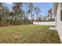 Spacious backyard with vibrant green grass, a white privacy fence, and natural wooded backdrop for a serene outdoor space at 13143 Sw 67Th Ave, Ocala, FL 34473