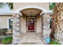 Inviting front entrance featuring stone pillars and a classic red door with decorative details at 2105 Sw 4Th St, Ocala, FL 34471