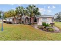 Charming single-story home featuring lush landscaping, mature palm trees, and a welcoming front entrance at 2105 Sw 4Th St, Ocala, FL 34471