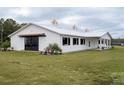 White horse barn with cupola, black doors, and landscaping at 2190 Nw 110Th Ave, Ocala, FL 34482