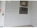 White vinyl siding and a window with a screen at 321 Katherine Pl, The Villages, FL 32162