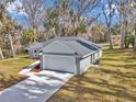 Gray house with attached garage and walkway, surrounded by trees at 4065 Sw 5Th Ave, Ocala, FL 34471