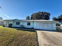 Front view of a single-story house with a two-car garage and a grassy yard at 6184 Sw 101St Pl, Ocala, FL 34476