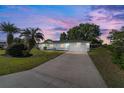 Exterior of the home at dusk, featuring lush landscaping and a spacious two-car garage at 6184 Sw 101St Pl, Ocala, FL 34476