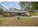 One-story house with a tan exterior, landscaping, and a large tree at 8465 Sw 202Nd Ter, Dunnellon, FL 34431