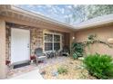 Front porch with stone accents, seating, and lush greenery at 8465 Sw 202Nd Ter, Dunnellon, FL 34431