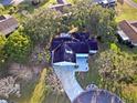 Aerial view of single-story home with driveway and mature trees at 10185 Se 175Th Ln, Summerfield, FL 34491